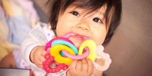 baby-girl-in-discomfort-chewing-on-teething-rings-picture-id872324046.jpg