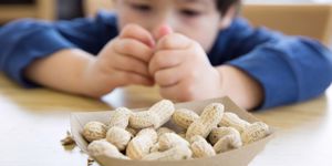 little-boy-eating-peanuts-picture-id497444988.jpg