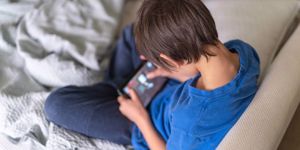 nineyear-old-ethnic-boy-plays-game-on-phone-picture-id1250718137.jpg