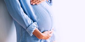 pregnant-woman-holds-hands-on-belly-at-home-interiors-picture-id669281410.jpg