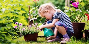 cute-little-girl-watering-plants-in-the-garden-picture-id1081678026.jpg