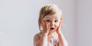surprised-shocked-child-toddler-girl-with-hands-on-her-cheeks-on-picture-id1167078560.jpg