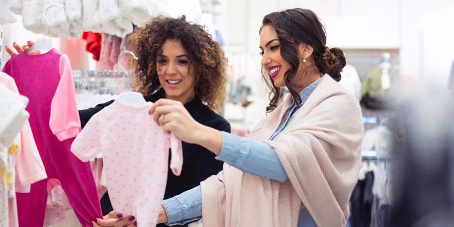 women picking out baby girl clothes