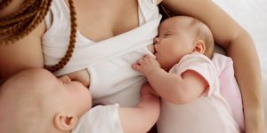 a mother breastfeeding twins