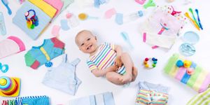 smiling baby surrounded by baby items