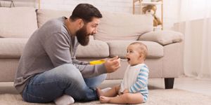 father-feeding-his-cute-baby-son-at-home-picture-id1135950316.jpg