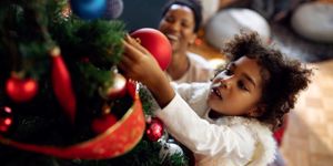 small-black-girl-decorating-christmas-tree-at-home-picture-id1281508900.jpg