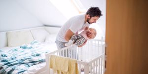 father-putting-a-sleeping-toddler-girl-into-cot-at-home-picture-id973089774.jpg
