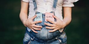female-hands-at-belly-with-with-boy-and-girl-cards-picture-id969841732.jpg