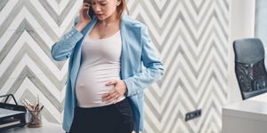 upset-pregnant-woman-talking-on-cellphone-in-office-picture-id1224523389.jpg