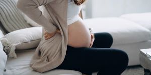 pregnant woman bump sat on sofa