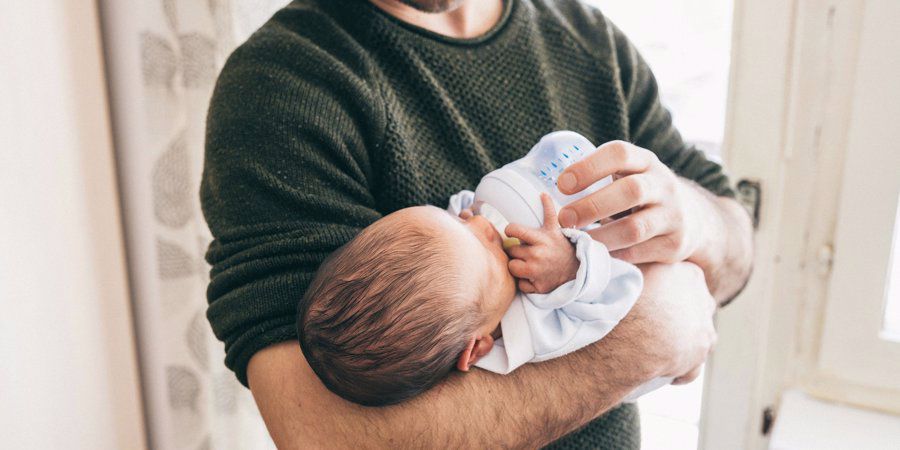 dad bottle feeding new baby