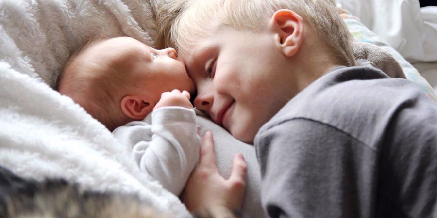 child hugging new sibling baby