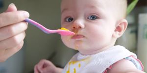 baby eating mango from a spoon
