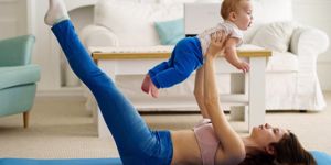mom lying down lifting baby in the air