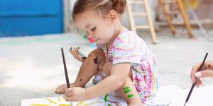 cute-little-caucasian-girl-enjoying-painting-at-the-backyard-with-picture-id1042756824.jpg