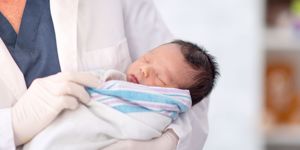 newborn baby swaddled by doctor