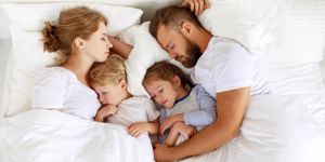 healthy-sleep-happy-family-parents-and-children-sleeping-in-white-bed-picture-id1184108281.jpg