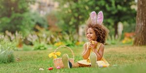 girl in bunny ears doing Easter egg hunt