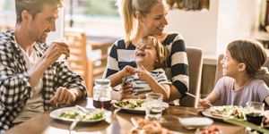 happy-family-having-fun-while-talking-during-lunch-time-at-dining-picture-id1127713968.jpg