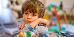 portrait-of-little-kid-boy-sad-on-birthday-child-with-lots-of-toy-picture-id649668608.jpg