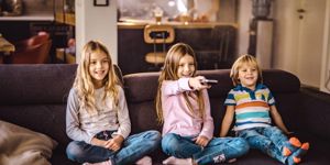 happy-kids-watching-tv-on-sofa-in-the-living-room-picture-id1129093654.jpg