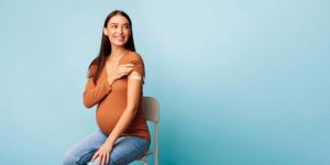 vaccinated-pregnant-woman-showing-arm-after-vaccine-injection-blue-picture-id1319057634.jpg