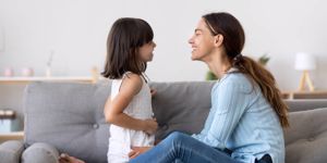 mother-spend-time-with-little-daughter-talking-sitting-on-couch-picture-id1070262182.jpg