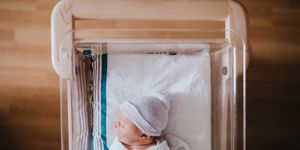newborn-baby-sleeping-in-hospital-bassinet-picture-id999302432.jpg