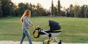 mother-enjoying-walk-carrying-her-little-child-in-his-baby-trolley-picture-id1059508598.jpg