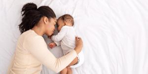 mum lying in bed with newborn baby