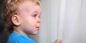 little-boy-looking-through-window-and-crying-picture-id512301886.jpg