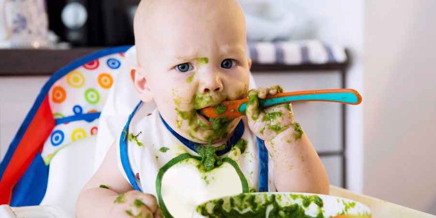 messy baby eating from spoon