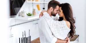 lovely-gently-couple-embracing-with-closed-eyes-at-kitchen-picture-id1162327901.jpg