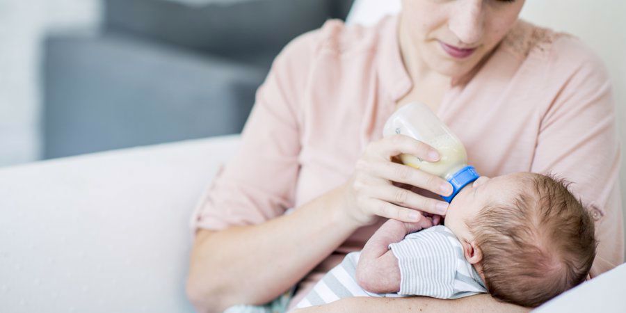 mum feeding anti colic bottle to baby