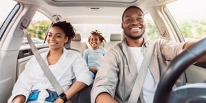family smiling and riding in the car together