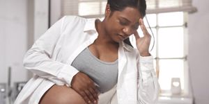 pregnant woman looking unwell at home